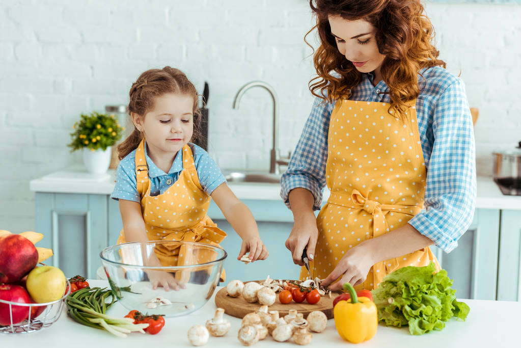 fille mignonne aidant mère cuisine légumes à la cuisine
 - Photo, image