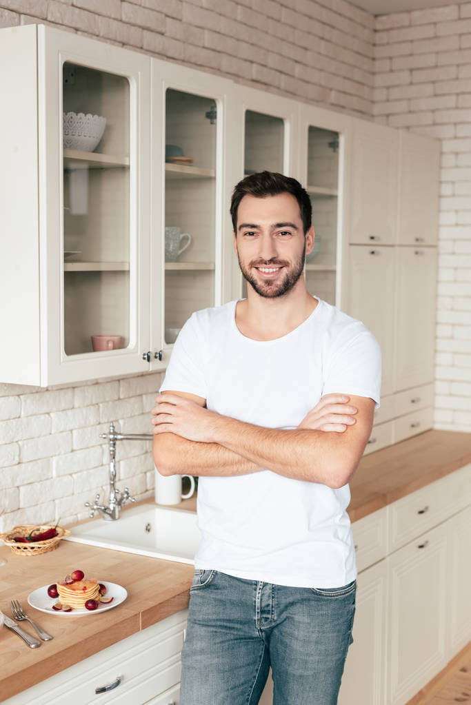 homme barbu souriant debout avec les bras croisés dans la cuisine
 - Photo, image