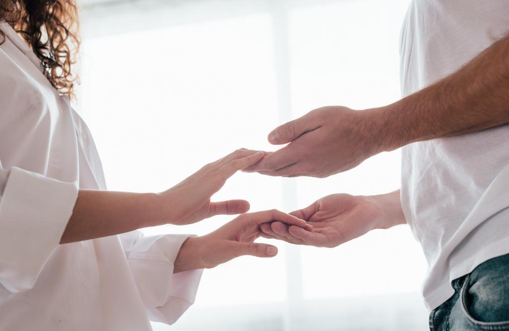 vue partielle du couple aimant se tenant la main à la maison
 - Photo, image