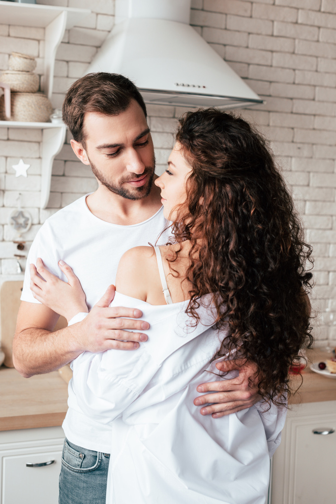 αγαπημένο ζευγάρι αγκαλιάζοντας σε άνετη κουζίνα το πρωί - Φωτογραφία, εικόνα