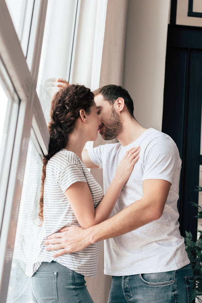 幸せなカップルでジーンズを受け入れ自宅でキスをし - 写真・画像