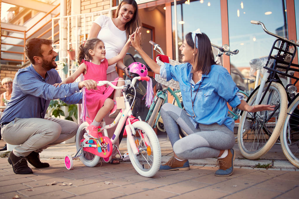 Polkupyörän myynti - Nuori perhe ostaa uuden polkupyörän pikkutytölle i
 - Valokuva, kuva