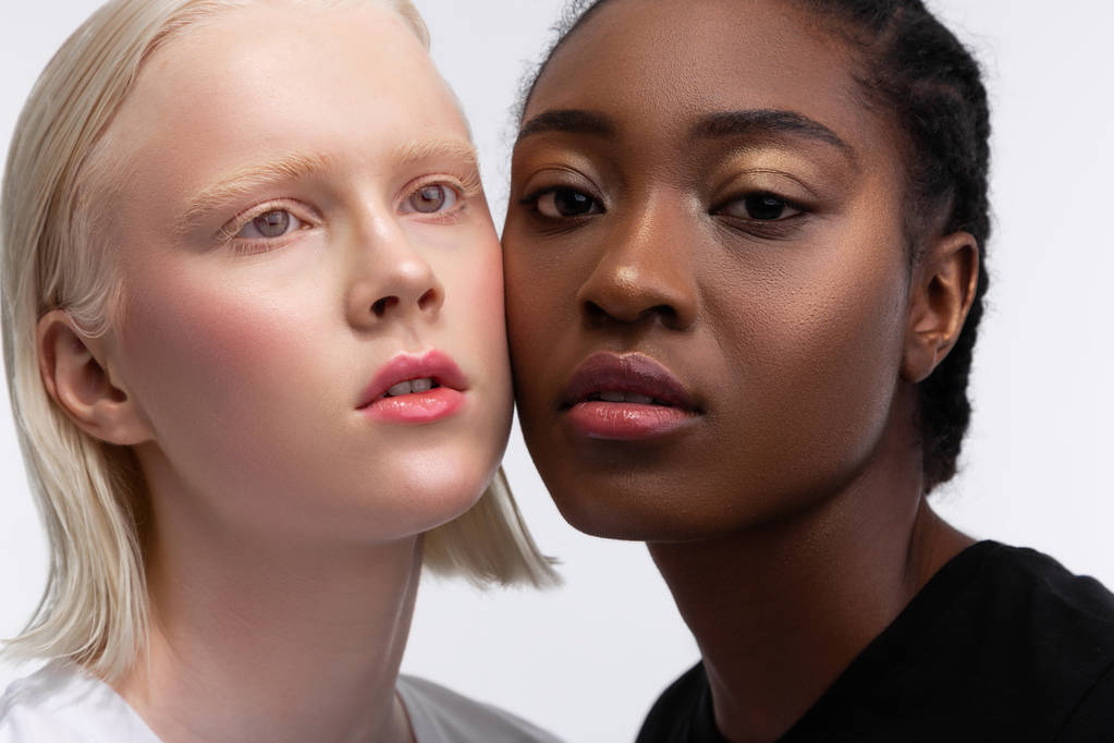 Models touching their cheeks while posing for multicultural issue - Photo, Image