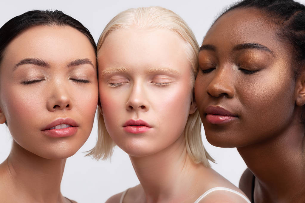 Tres hermosas mujeres con diferente piel cerrando los ojos mientras posan
 - Foto, Imagen