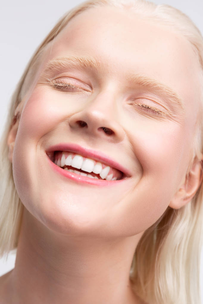 Vrolijke blonde vrouw met witte wenkbrauwen die in grote lijnen glimlachen - Foto, afbeelding