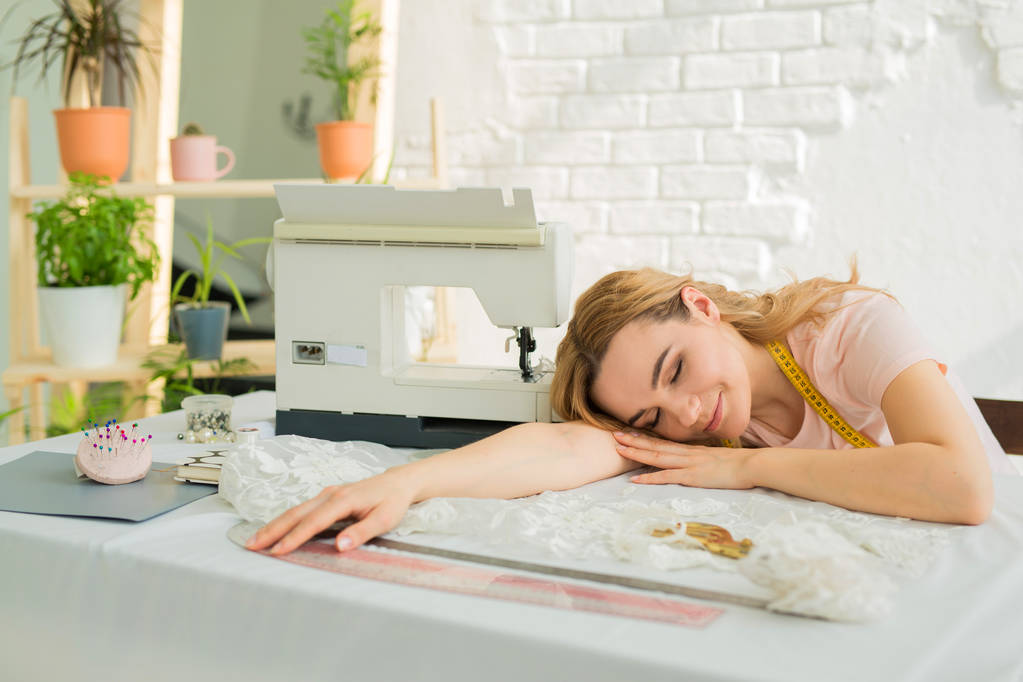 belle jeune fille couturière designer au travail dormir à la table près de la machine à coudre
 - Photo, image