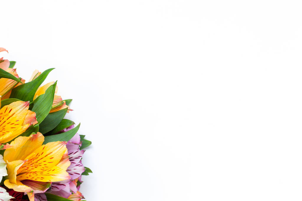 Boeket van kleurige bloemen alstroemeria op witte achtergrond. Flat lag. Horizontaal. Mockup met kopie ruimte voor wenskaart, sociale media, bloemen bezorgen, Moederdag, Vrouwendag. - Foto, afbeelding