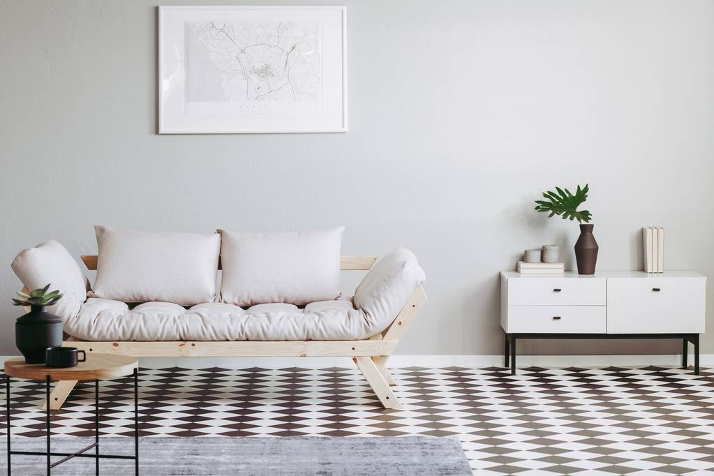 Futon escandinavo na sala de estar interior bege com piso preto e branco
 - Foto, Imagem