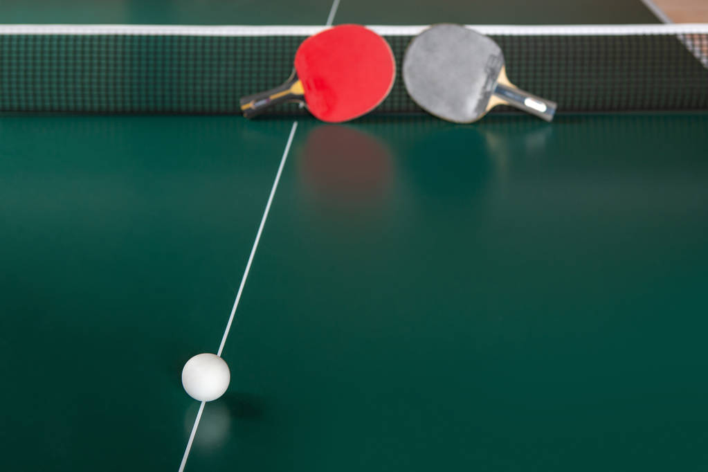 dos raquetas de ping-pong y una pelota sobre una mesa verde
.  - Foto, imagen