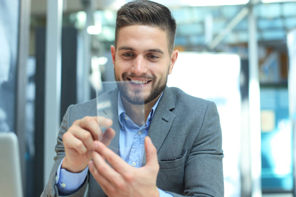 Future concept. Businessman holds futuristic transparent smart phone. - Photo, Image