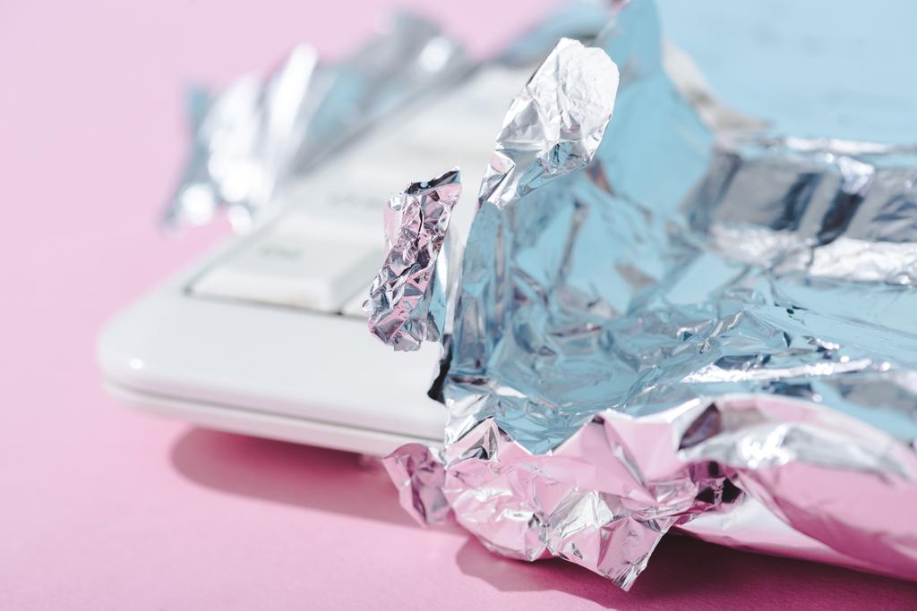 enfoque selectivo del teclado de la computadora envuelto en lámina de plata en rosa, concepto de barra de chocolate
 - Foto, Imagen