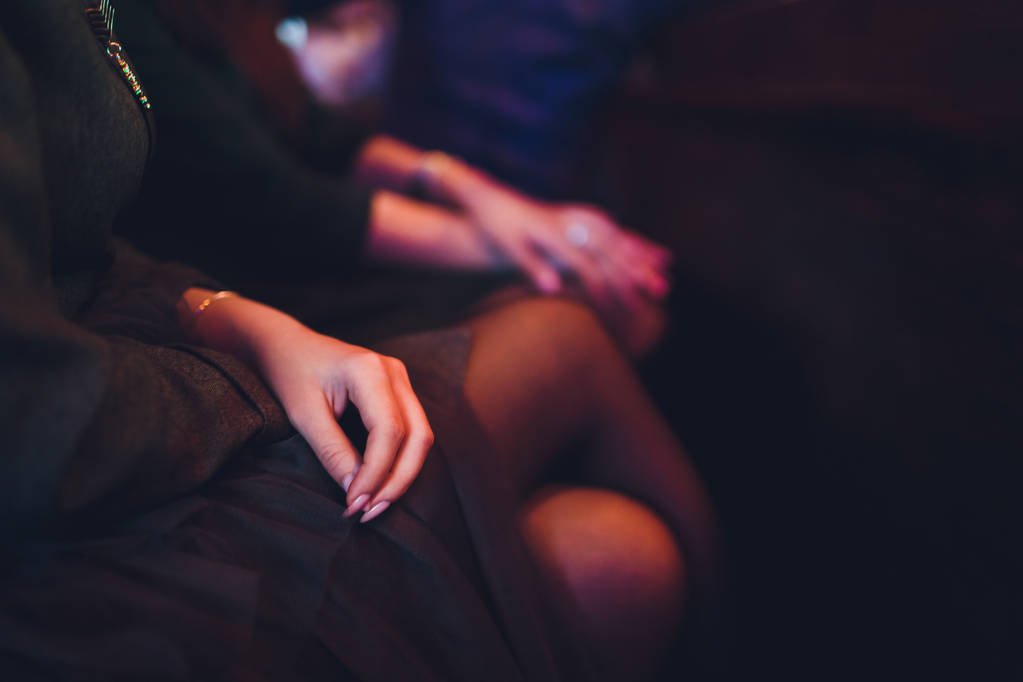 Close up of female hand touching silky perfect leg. Lady sitting. - Photo, Image