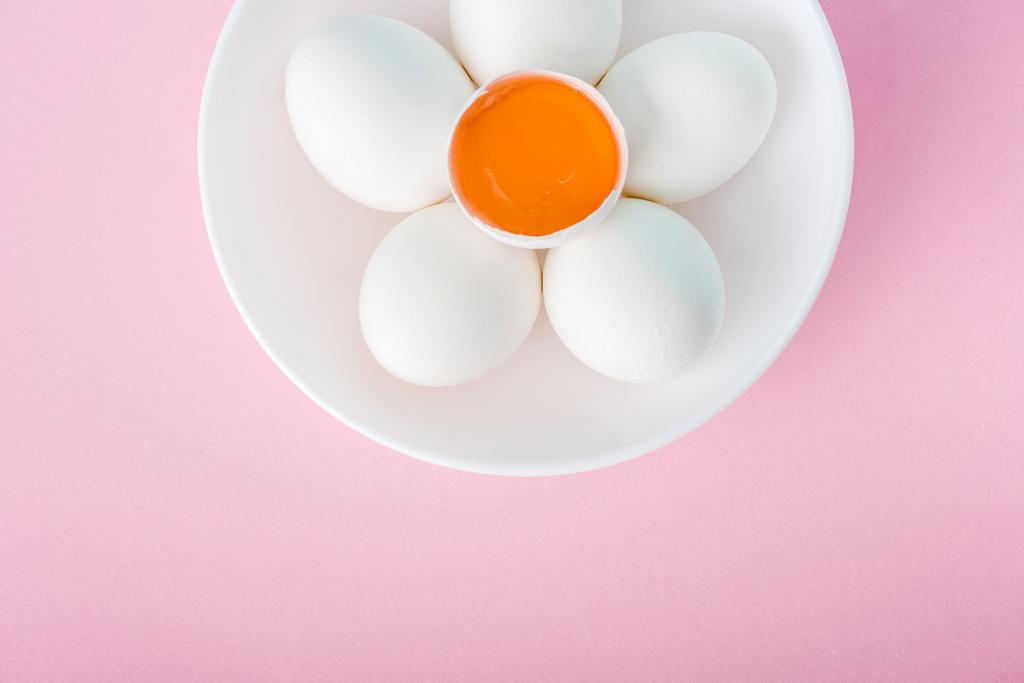 top view of plate with flower made of eggs and egg yolk on pink with copy space - Photo, Image
