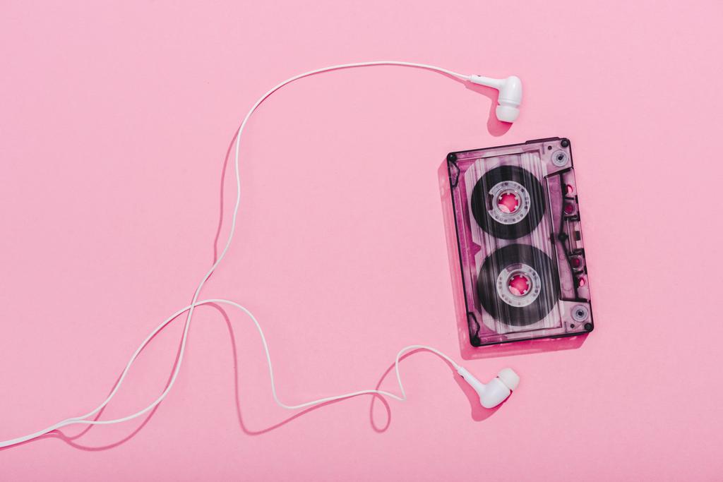 top view of vintage audio cassette with earphones on pink, music concept - Photo, Image
