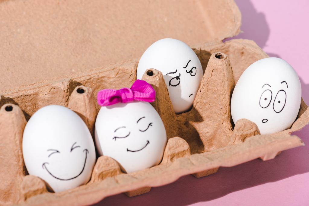 vejce s různou tváří v vaječného kartonu na růžovém - Fotografie, Obrázek