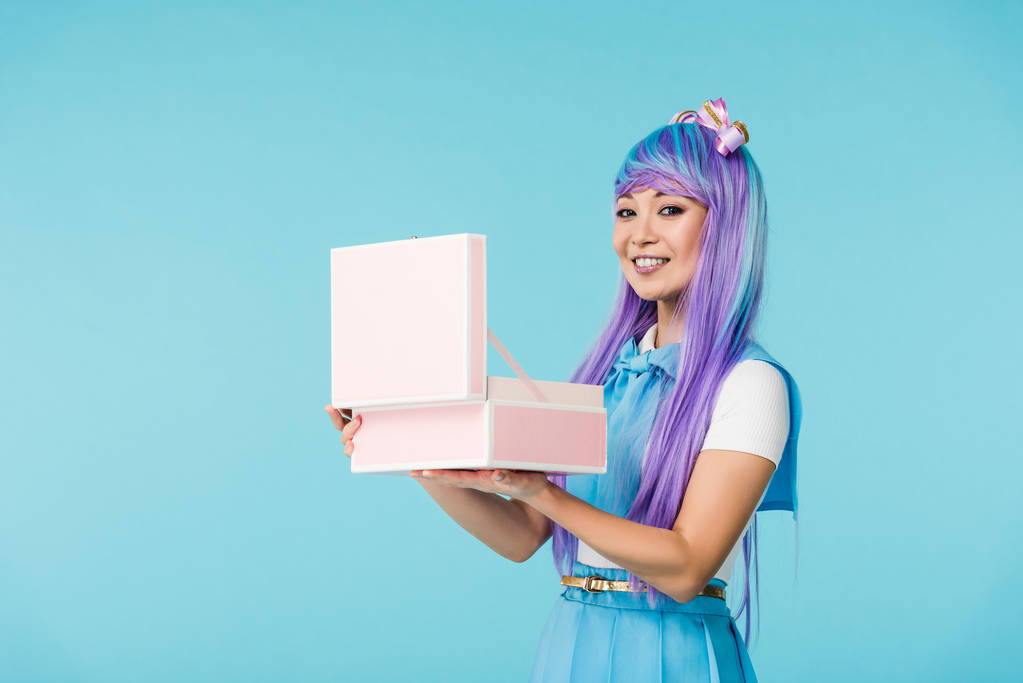 sourire asiatique anime fille tenant ouvert mallette isolé sur bleu
 - Photo, image