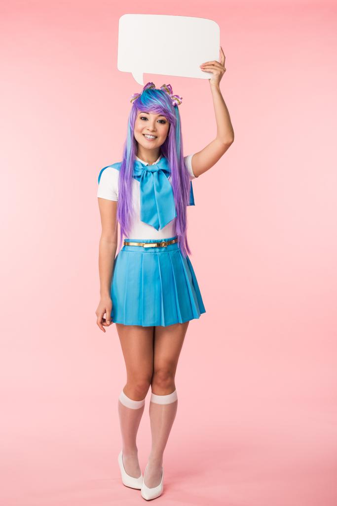 Full length view of excited asian anime girl in purple wig holding speech bubble on pink - Photo, Image