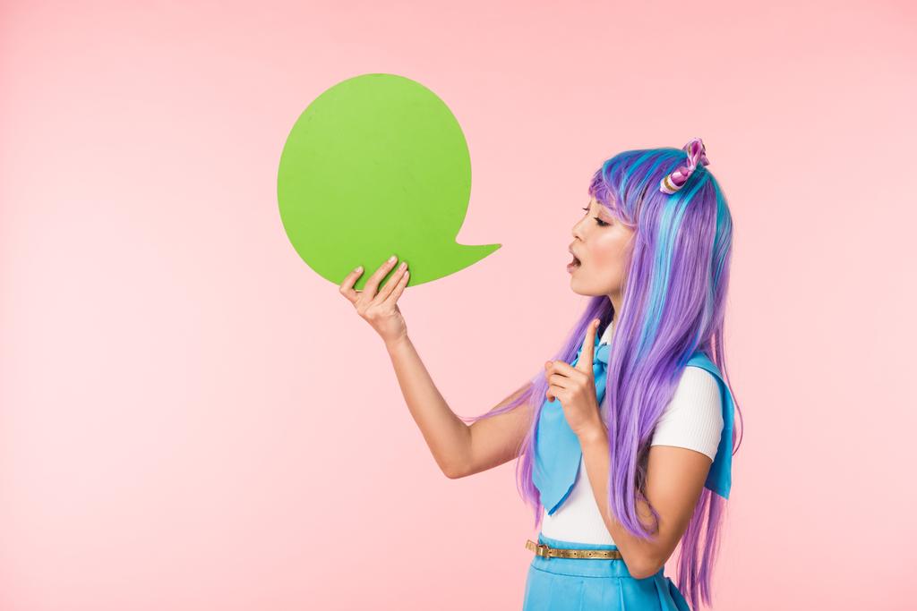 Ázsiai anime lány gazdaság zöld beszéd buborék és mutatja ötlet jel rózsaszín - Fotó, kép