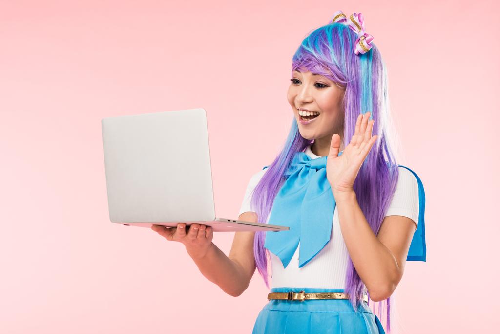 Joyful asian anime girl waving hand at laptop screen on pink - Photo, Image