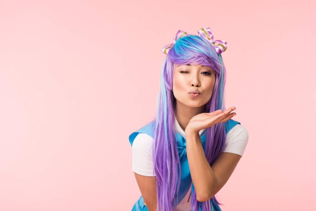 Asya anime kız hava öpücük gönderme ve pembe izole göz kırpma - Fotoğraf, Görsel
