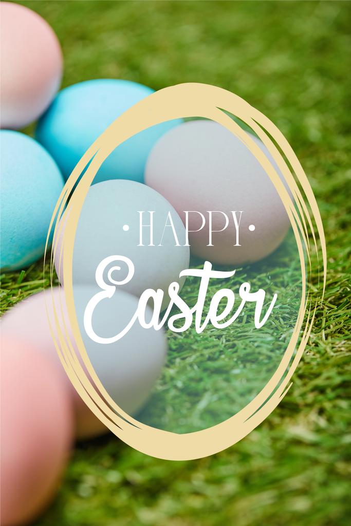 pile of multicolored painted chicken eggs with happy Easter lettering on green grass - Photo, Image