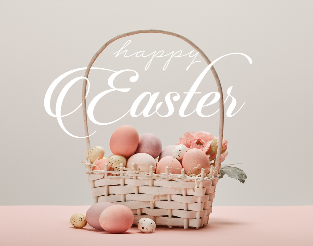Weidenkorb mit rosa bemalten Eiern, Blumen und frohem Osterfest weißen Schriftzug auf grauem Hintergrund - Foto, Bild