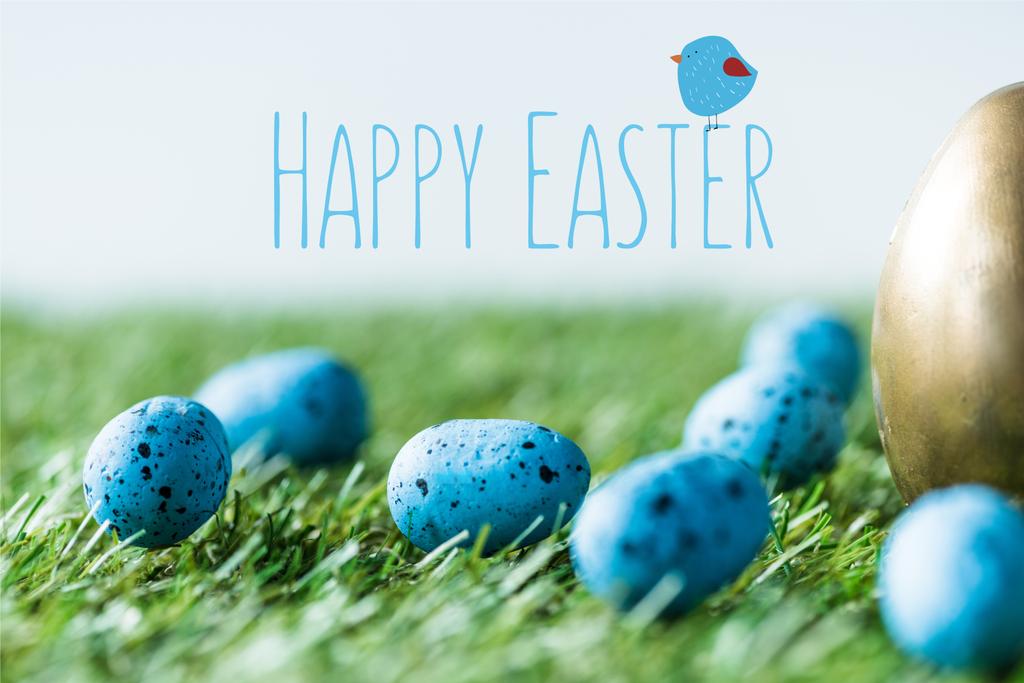 uova di quaglia dipinte blu su erba verde vicino all'uovo di pollo dorato e felice iscrizione pasquale
 - Foto, immagini