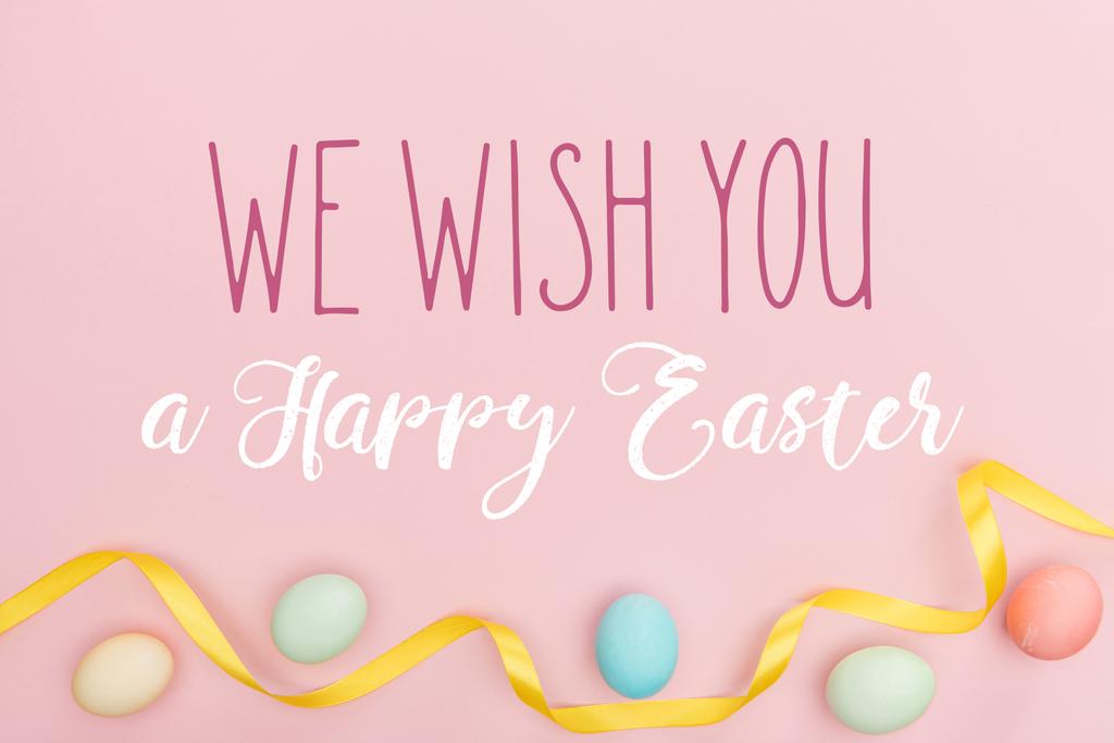 felülnézet festett sokszínű csirke tojás és szatén szalagot rózsaszín háttérrel kívánunk Boldog húsvéti betűkkel - Fotó, kép