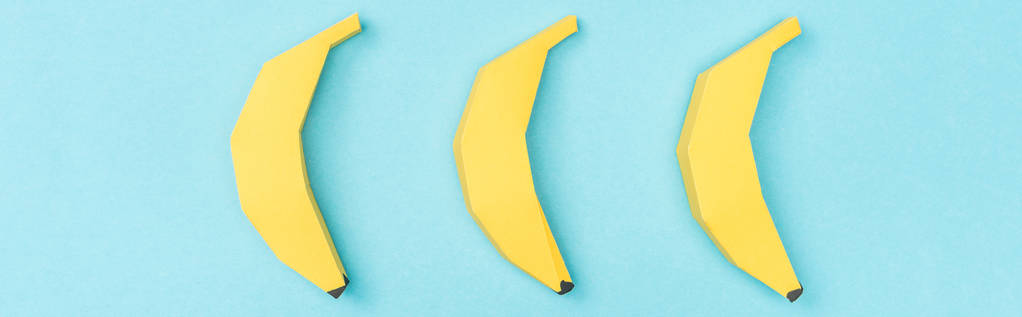 πανοραμικό πλάνο από κίτρινες μπανάνες χαρτιού απομονωμένη στο μπλε - Φωτογραφία, εικόνα