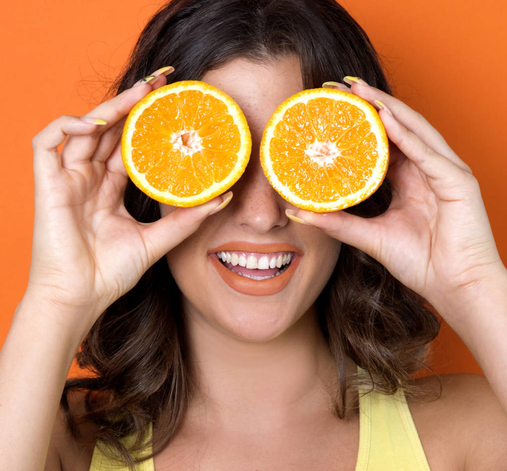 Nuori nainen poseeraa oranssi viipaleita
 - Valokuva, kuva