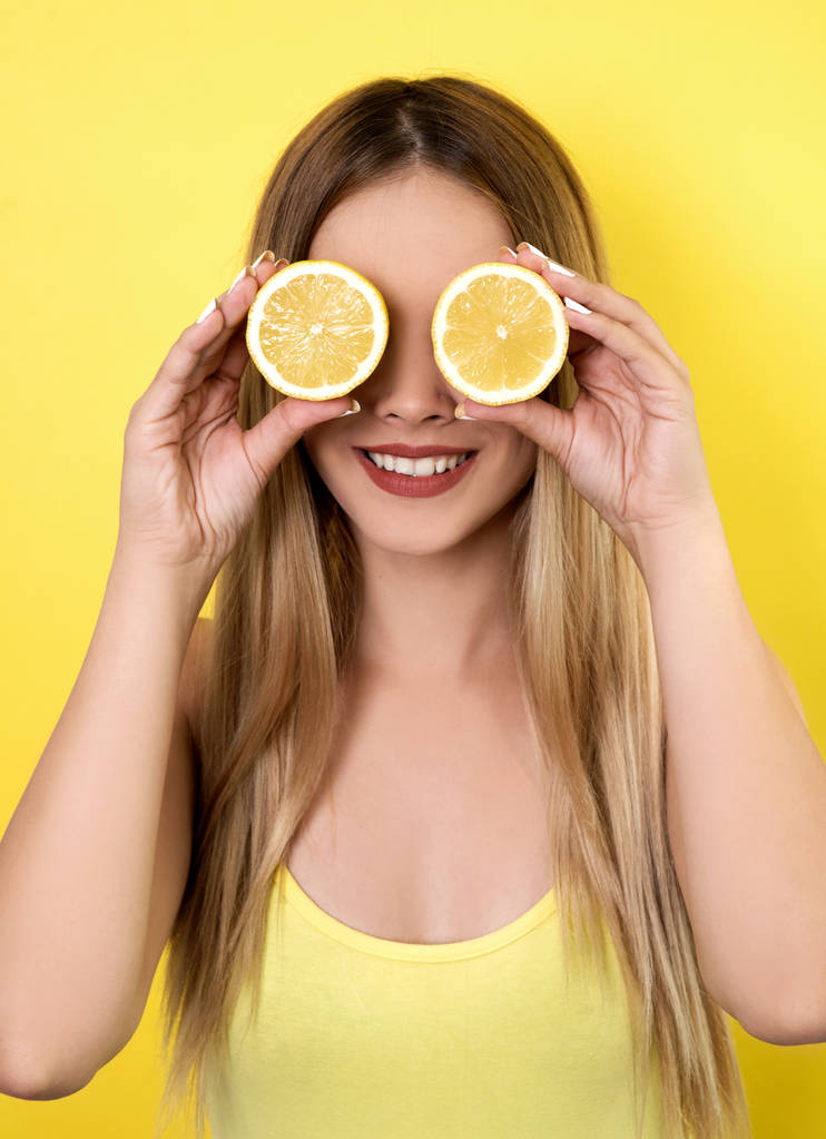 Mujer joven posando con rodajas de limón
 - Foto, Imagen