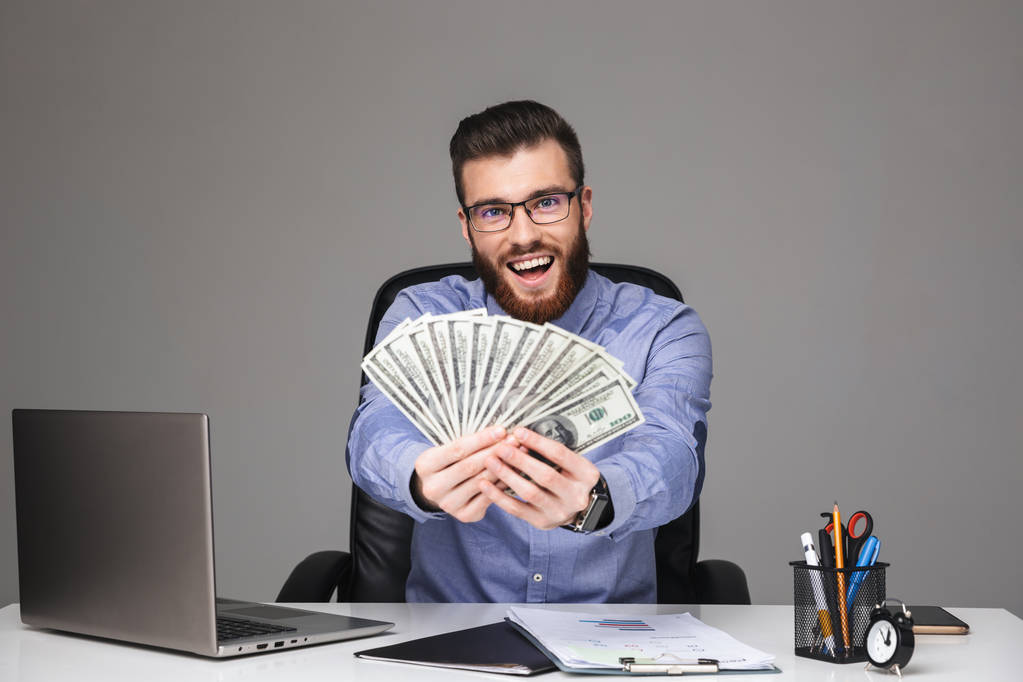 Szczęśliwy Brodaty elegancki człowiek w okularach pokazując pieniądze - Zdjęcie, obraz
