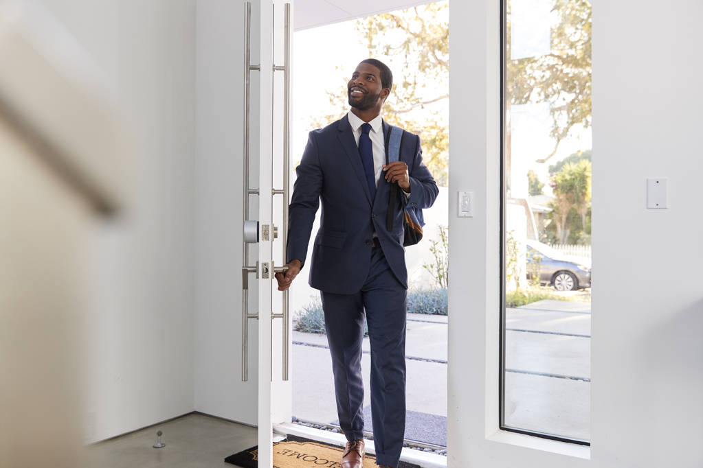 Empresario con traje abriendo la puerta regresando a casa del trabajo
 - Foto, imagen