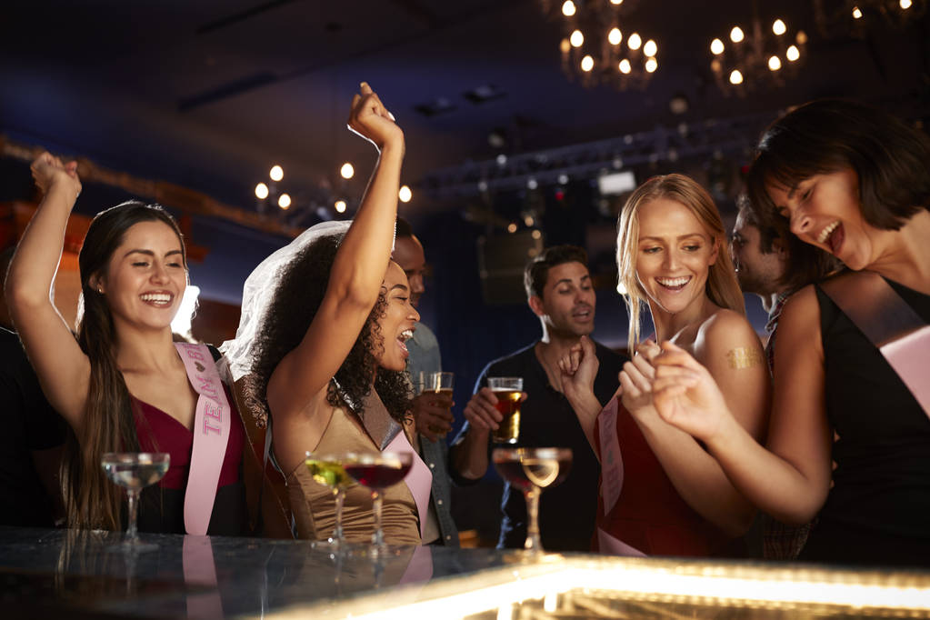 Gruppe tanzender Freundinnen feiert mit Braut auf Polterabend in Bar - Foto, Bild