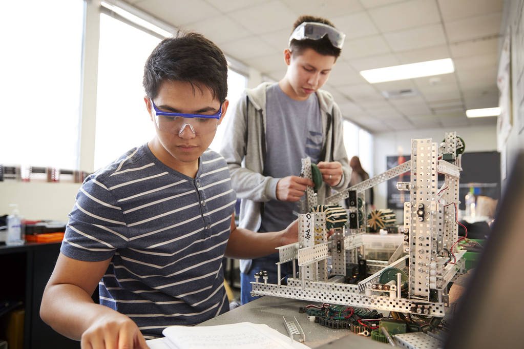 Dos estudiantes universitarios varones que construyen la máquina en robótica de ciencia o clase de ingeniería
 - Foto, Imagen