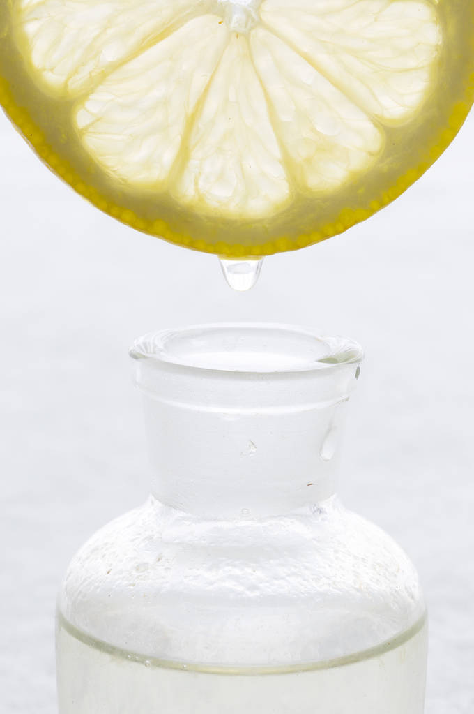 Limondan şişeye uçucu yağ düşüyor. Essence sıvı kozmetik. Parfüm.Aromaterapi. - Fotoğraf, Görsel