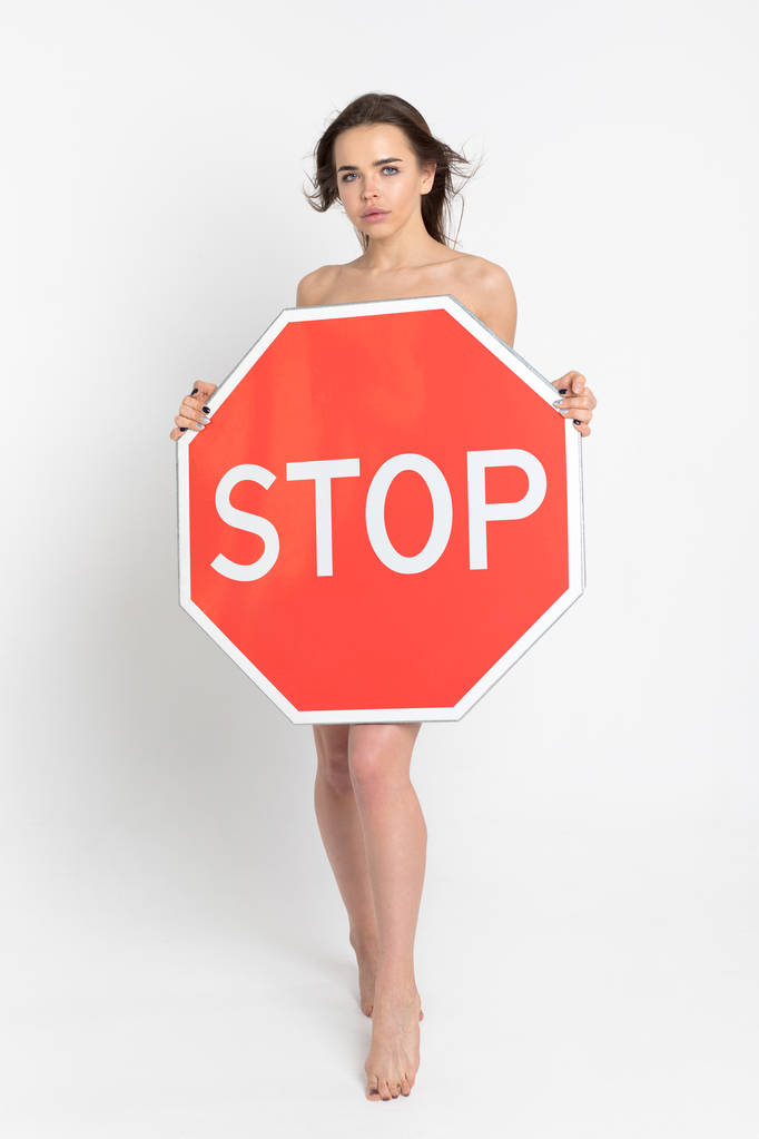 Szexi fiatal nő kezében egy nagy piros stop tábla. - Fotó, kép