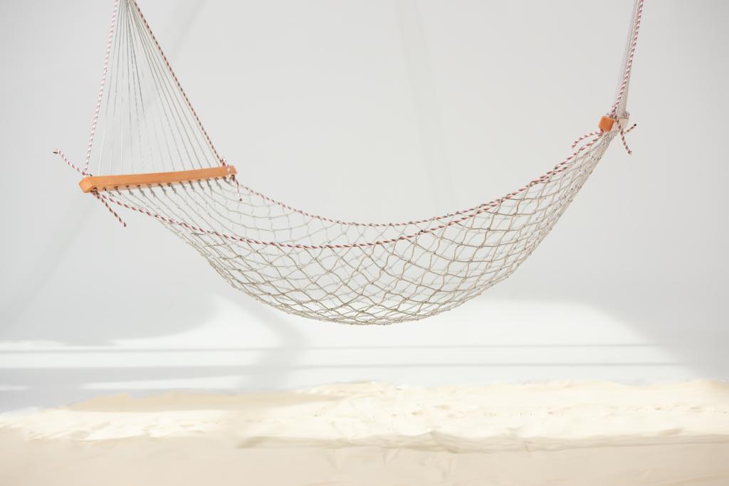 hanging hammock made of net over sand on grey - Photo, Image