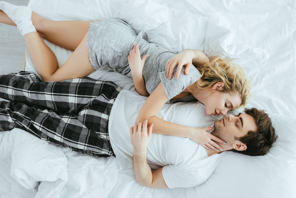 Widok z góry szczęśliwego para przytulanie podczas leżącego na łóżku  - Zdjęcie, obraz
