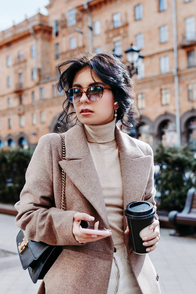 Модна бізнес-леді п'є каву і смс на вулиці міста
 - Фото, зображення