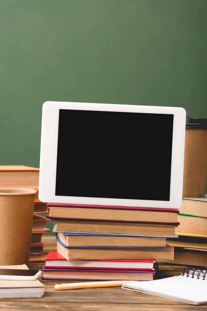 livres, cahiers, stylo, gobelets jetables, smartphone et tablette numérique avec écran blanc isolé sur vert
 - Photo, image