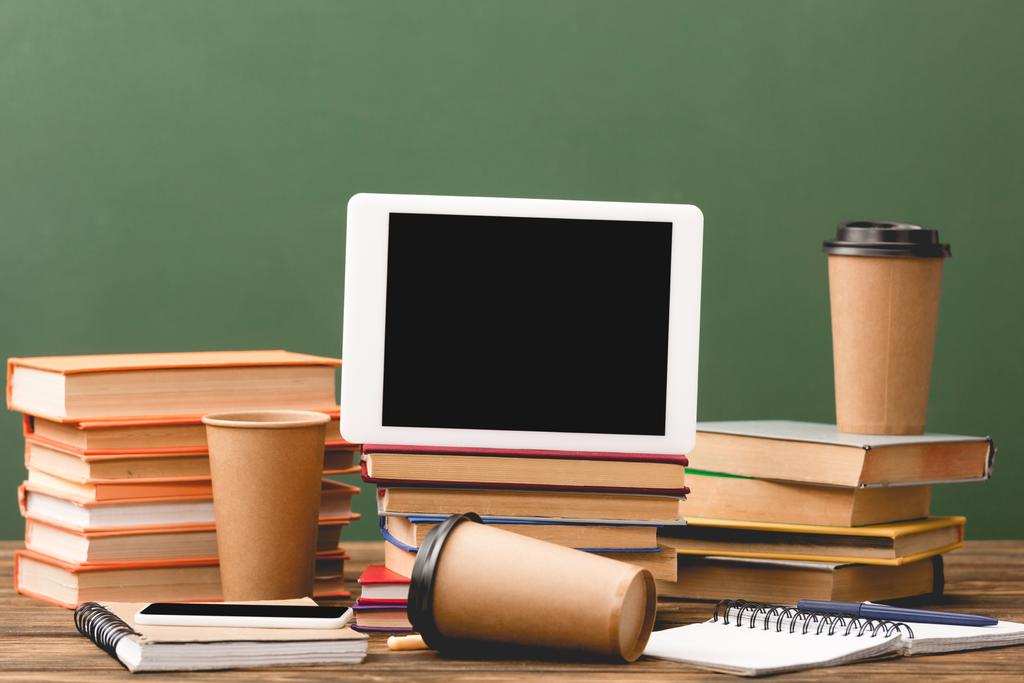 книги, блокноти, одноразові чашки, ручки, смартфон і цифровий планшет з порожнім екраном ізольовані на зеленому
 - Фото, зображення
