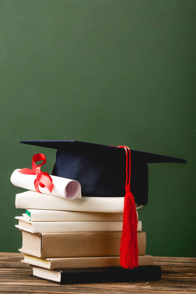 livres, casquette académique et diplôme sur surface en bois isolé sur vert
 - Photo, image