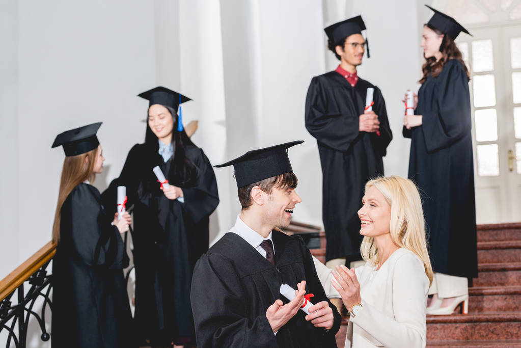 mezuniyet kap mutlu oğlu seçici odak öğrencilerin yanında anne bakarak  - Fotoğraf, Görsel