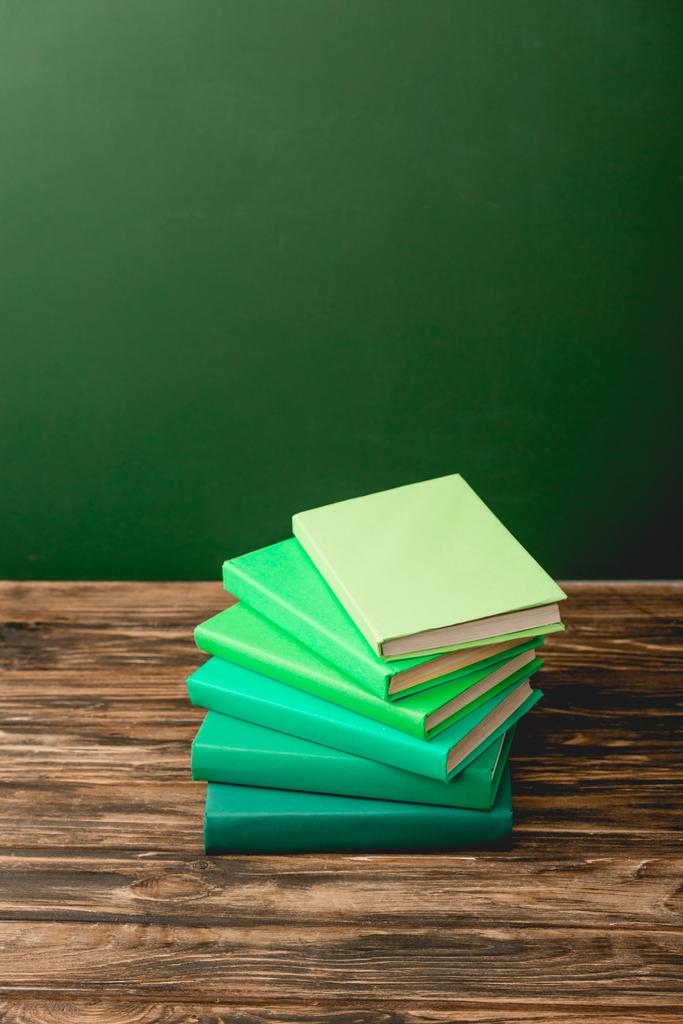 yeşil izole ahşap yüzey üzerinde renkli kitap yığını - Fotoğraf, Görsel