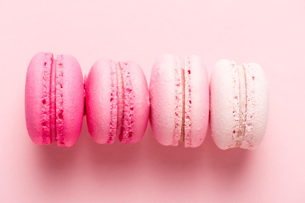 Draufsicht auf colorul macarons auf rosa Oberfläche - Foto, Bild