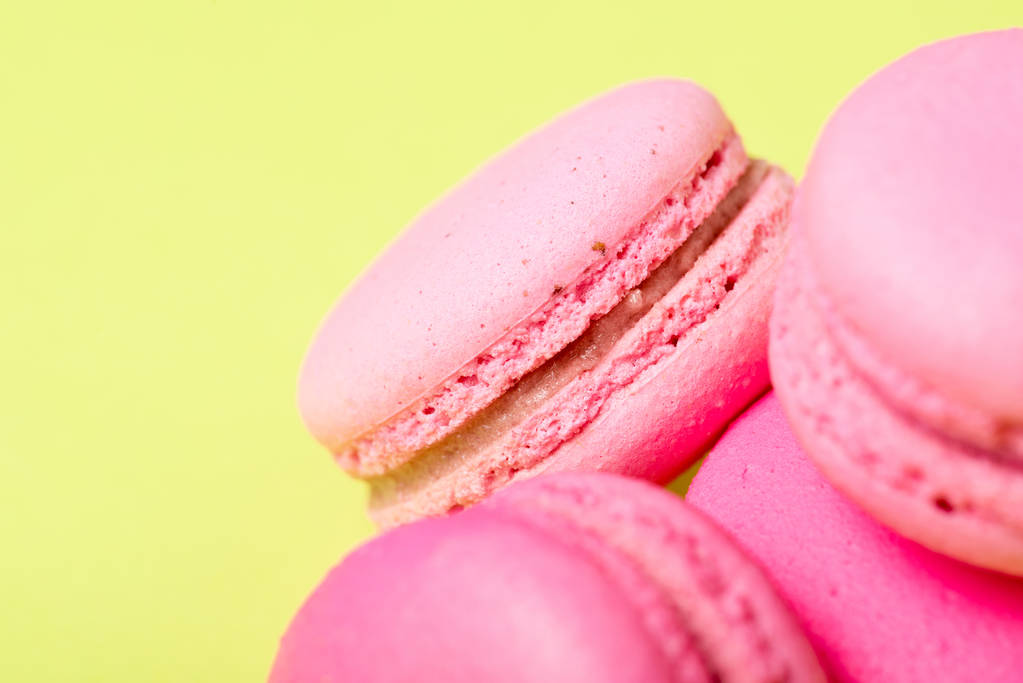leckere rosa Macarons mit Füllung auf gelber Oberfläche - Foto, Bild