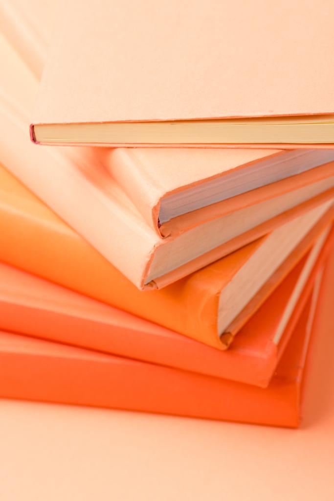 pile de livres à couverture rigide colorée sur la surface orange
 - Photo, image