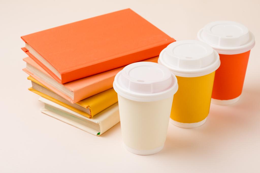 stack of books and colorful disposable cups on light surface - Photo, Image