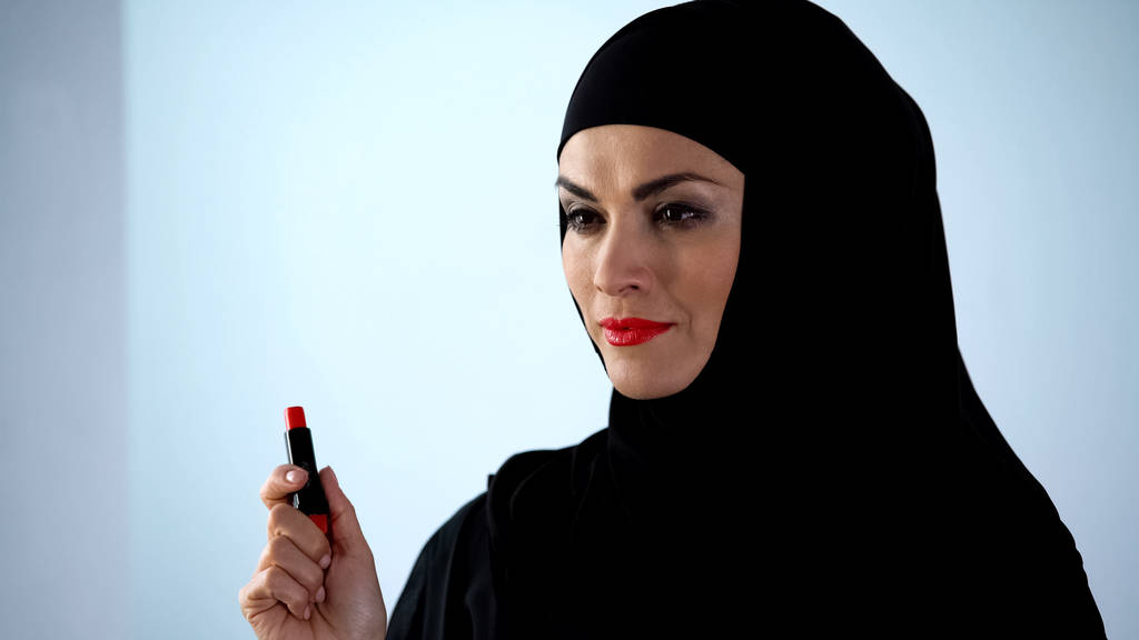 赤い口紅を持つ自信のあるアラブの女性、夜のメイクアップ、美しさを適用 - 写真・画像